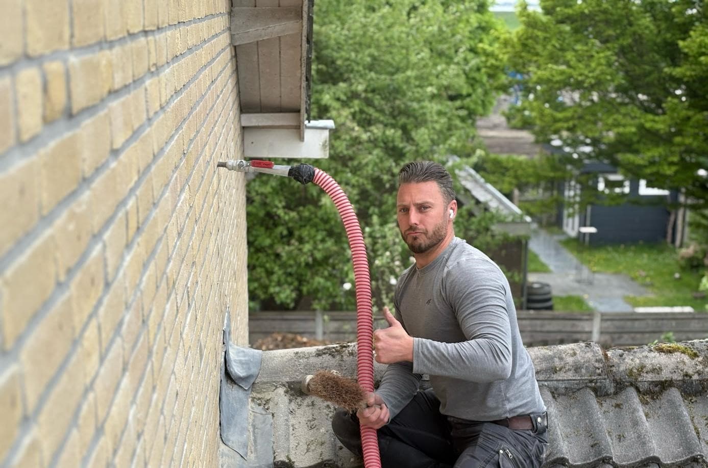 Een vakman van Jongejans isoleert de spouw van een bakstenen woning